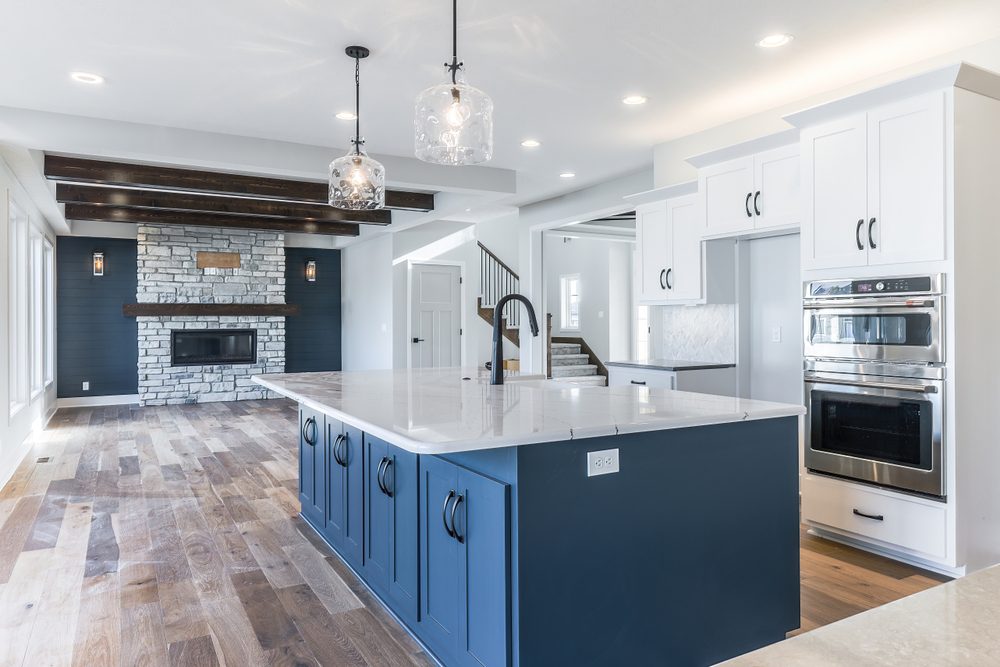 A Freshly Remodeled Kitchen With A Blue And White Countertop With A Modern Matte Black Sink.