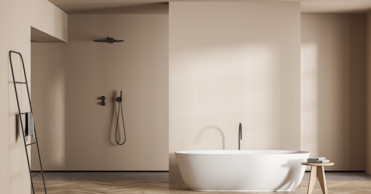 A large bathroom with beige showers, a standing tub in the middle next to an open shower, and a metal drying rack.